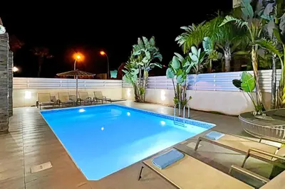 a swimming pool at night with chairs around it at Villa Anastasia - Fig Tree Bay Area in Protaras