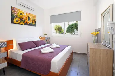 a bedroom with a bed with a purple blanket at Villa Anastasia - Fig Tree Bay Area in Protaras