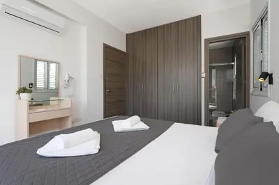 a bedroom with a bed with two white towels on it at Villa Anastasia - Fig Tree Bay Area in Protaras