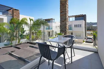 a balcony with a table and chairs on a balcony at Villa Anastasia - Fig Tree Bay Area in Protaras