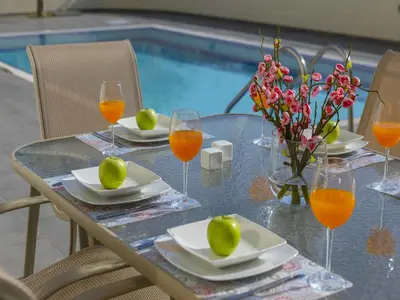 a table with plates and glasses of orange juice at Protaras Villa Theodora 1 in Protaras