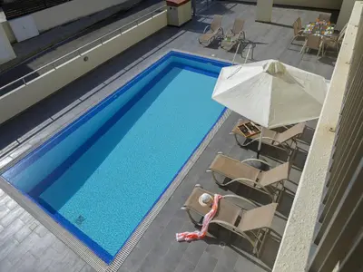 an overhead view of a pool with chairs and an umbrella at Protaras Villa Theodora 1 in Protaras