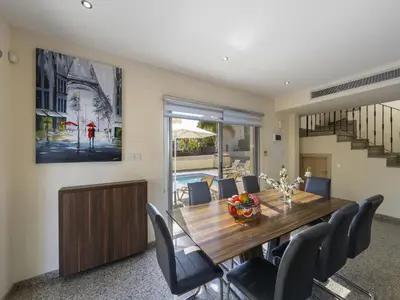 a dining room with a wooden table and chairs at Protaras Villa Theodora 1 in Protaras