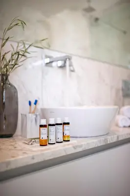a bathroom counter with three bottles of essential oils on it at Eros Cyprus in Ayia Napa