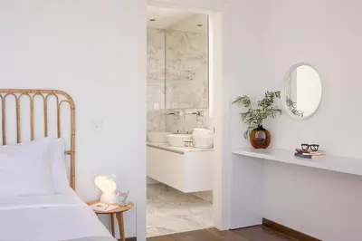 a bedroom with a bed and a bathroom with a mirror at Eros Cyprus in Ayia Napa