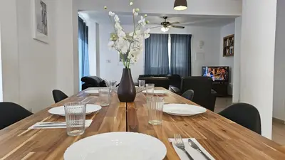 a dining room table with white plates and a vase with flowers at STAY Villa Anemone in Protaras