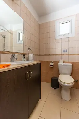 a bathroom with a toilet and a sink and a mirror at STAY Villa Anemone in Protaras