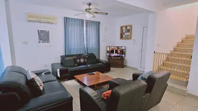 a living room with black leather furniture and a tv at STAY Villa Anemone in Protaras