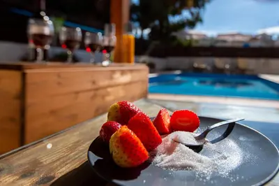 a plate of strawberries on a table next to a swimming pool at STAY Villa Anemone in Protaras