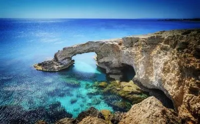 a natural arch in the water on a rocky coast at My Holiday in Ayia Napa