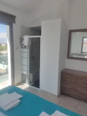 a bathroom with a glass shower and a mirror at Villa Ruby Yiasemina in Ayia Napa