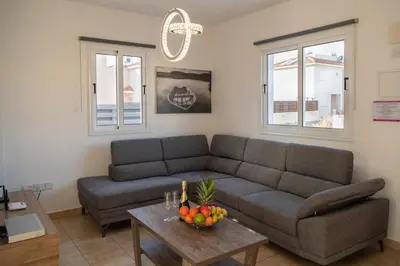 a living room with a couch and a table with fruit at Villa Ruby Evelyn in Protaras