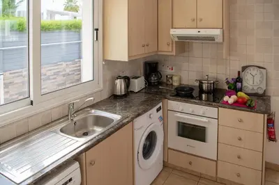 a kitchen with a sink and a washing machine at Villa Ruby Evelyn in Protaras