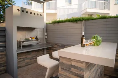 a patio with a white table and a grill at Villa Ruby Evelyn in Protaras