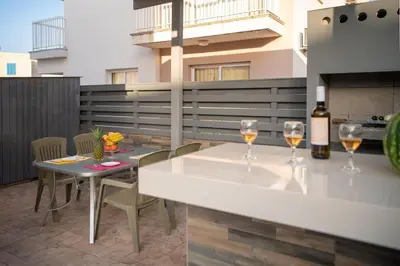 a patio with a table and two glasses of wine at Villa Ruby Evelyn in Protaras
