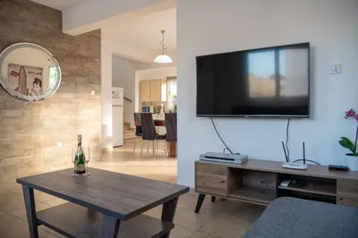 a living room with a flat screen tv on a wall at Villa Ruby Evelyn in Protaras