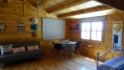 a room with a couch and a table in a cabin at Happy Glamping Cy in Ayios Theodhoros