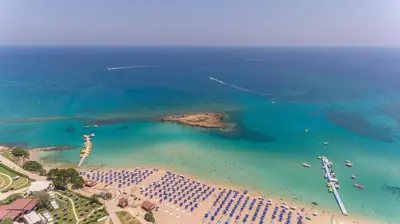 an aerial view of a beach with umbrellas and the ocean at Leucolla Hill & Sea in Protaras