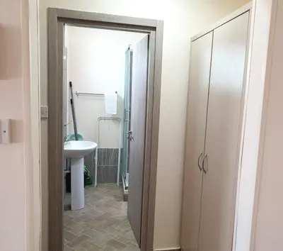 a bathroom with a door leading to a sink at Leucolla Hill & Sea in Protaras