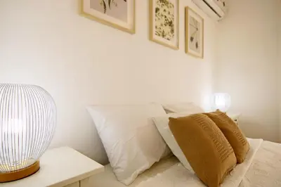 a bed with white pillows and a lamp on a table at Phaedrus Living Luxury Flat Protaras Sea View 9 in Protaras