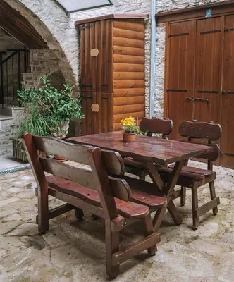 a wooden table and a bench in a patio at Lazaros Stonehouse in Pano Lefkara