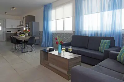 a living room with a couch and a table with wine glasses at Villa Ivory - Seafront in Ayia Napa