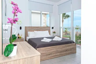 a bedroom with a bed and a large window at Villa Ivory - Seafront in Ayia Napa