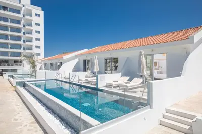 a villa with a swimming pool and a building at Bohemian Gardens Hotel in Protaras