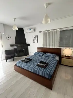 a bedroom with a bed and a table and a piano at Top floor apartment in Nicosia with view! in Nicosia