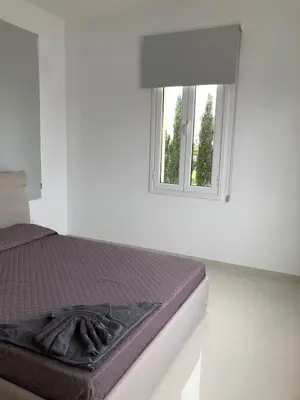 a bed in a white room with a window at Oasi Rejuve Poseidon in Meneou