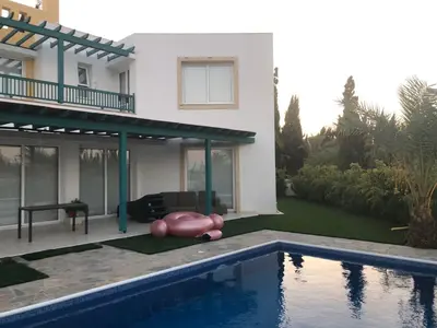a house with a swimming pool in front of a house at Oasi Rejuve Poseidon in Meneou
