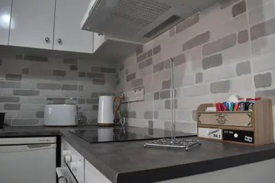 a kitchen with white cabinets and a counter top at Marias Apartment - in city centre,near beach in Larnaka