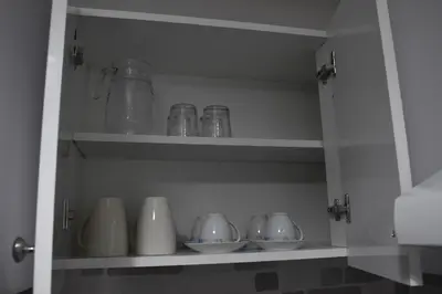 a shelf with cups and bowls in a kitchen at Marias Apartment - in city centre,near beach in Larnaka