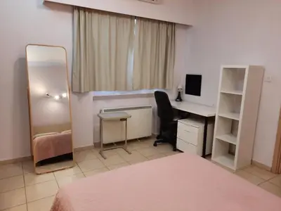 a bedroom with a desk and a bed and a mirror at 3 Bedroom Apartment in Nicosia