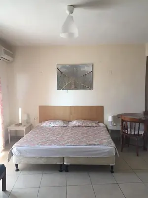 a bedroom with a bed and a bridge painting on the wall at Olimpus Garden Homes in Ayia Napa