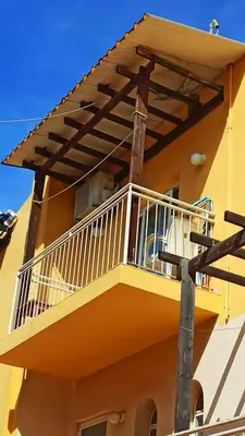 a balcony of a yellow building with a deck at Olimpus Garden Homes in Ayia Napa