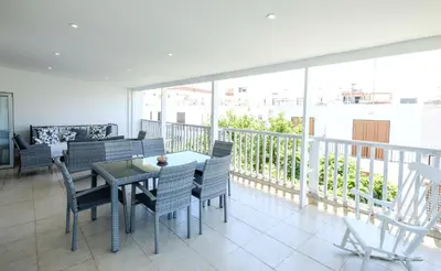 a dining room with a table and chairs on a balcony at Lovely 2 BR Vacation Apt Kohili Beach - 3 Min Walk in Paralimni