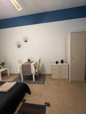 a bedroom with a bed and a table and a cabinet at Past or Tail rooms in Larnaka
