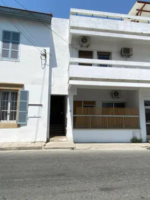 a white building with a door and a balcony at Past or Tail rooms in Larnaka