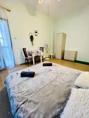 a large bed in a room with a table at Past or Tail rooms in Larnaka