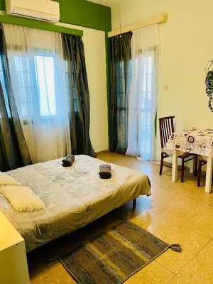 a bedroom with a bed and a table and chairs at Past or Tail rooms in Larnaka