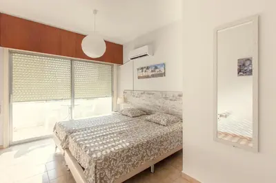 a bedroom with a bed and a large window at Furnished Seafront Studio in Larnaka