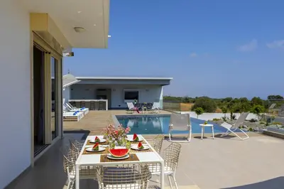 a patio with a table and chairs and a pool at Villa Elite in Protaras