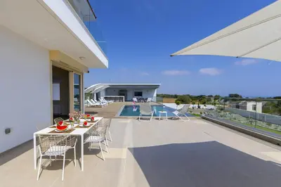 a patio with a table and chairs on a balcony at Villa Elite in Protaras