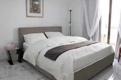 a bedroom with a large bed with white sheets at Apartment,NEAR THE BEACH Pinikoudes in Larnaka