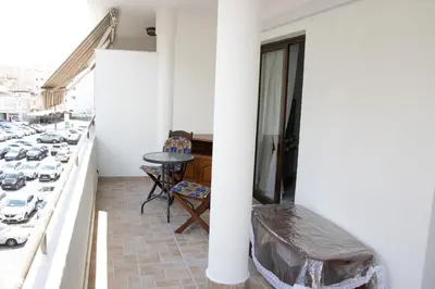 a balcony with a table and chairs and cars at Apartment,NEAR THE BEACH Pinikoudes in Larnaka