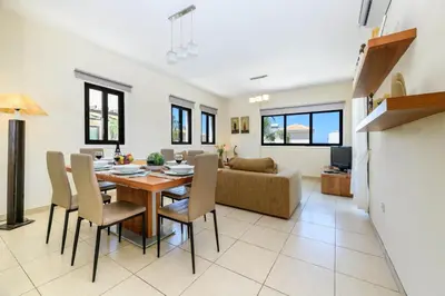 a dining room and living room with a table and chairs at Protaras Centro Villa in Protaras