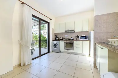 a kitchen with white appliances and a large window at Protaras Centro Villa in Protaras