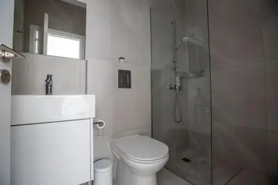a bathroom with a shower and a toilet and a sink at Ocean 11 Villa in Protaras