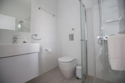 a white bathroom with a toilet and a shower at Ocean 11 Villa in Protaras